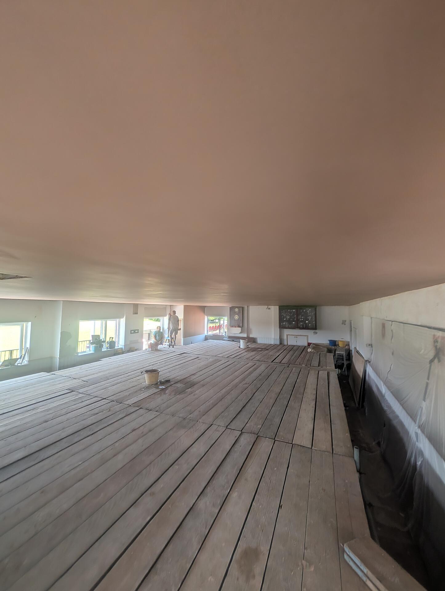 Clubhouse function room with the new ceiling skimmed and drying above the old timber floor