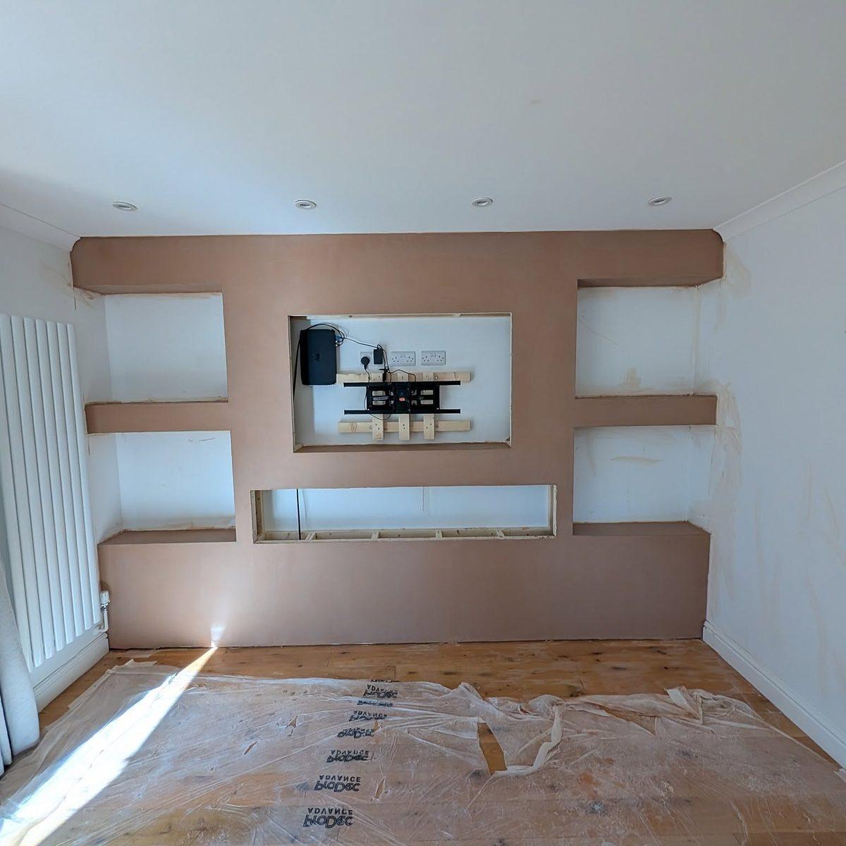 Interior with smooth, freshly finished alcove shelving and the floor covered in protective sheeting